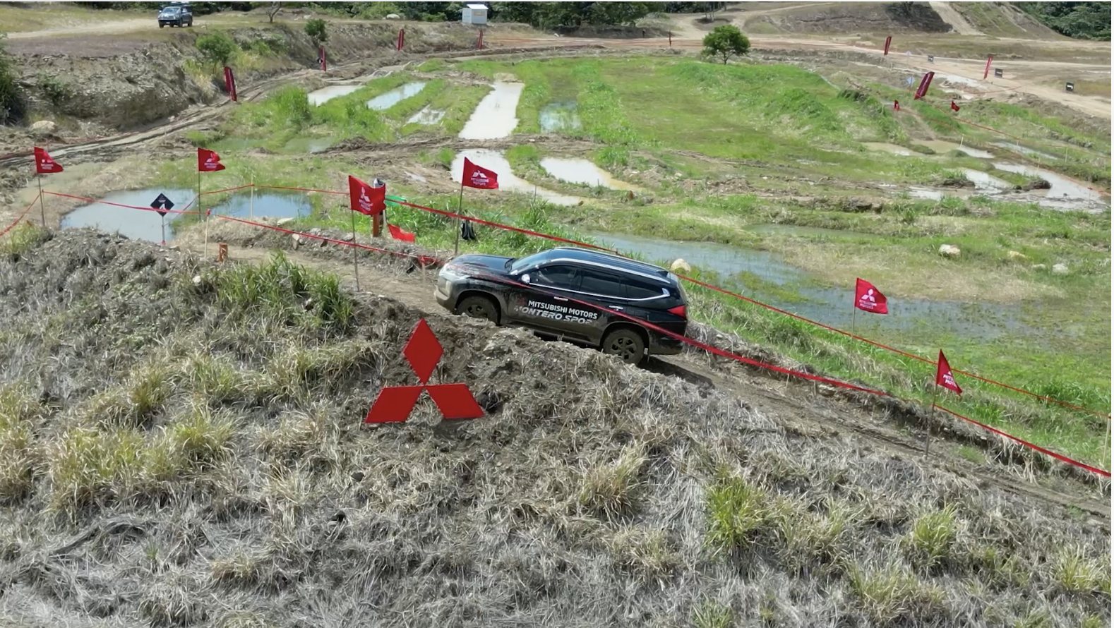Mitsubishi Montero Sport subiendo una pendiente señalizada con banderas de la marca